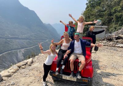 Jeep driving along Ma Pi Leng Pass with panoramic mountain views in Ha Giang